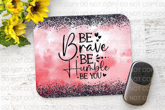 a pink and black mouse pad with the words be brave on it